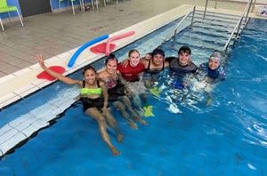 Adults participating in a swimming class.