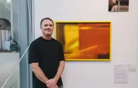 a man standing in front of a painting