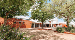 Entrance of Warnbro Community Library with red brick exterior and trees in the courtyard.