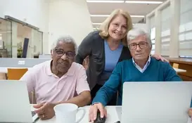 a group of people sitting at a table with a computer