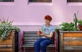 a woman sitting on a bench holding a plant