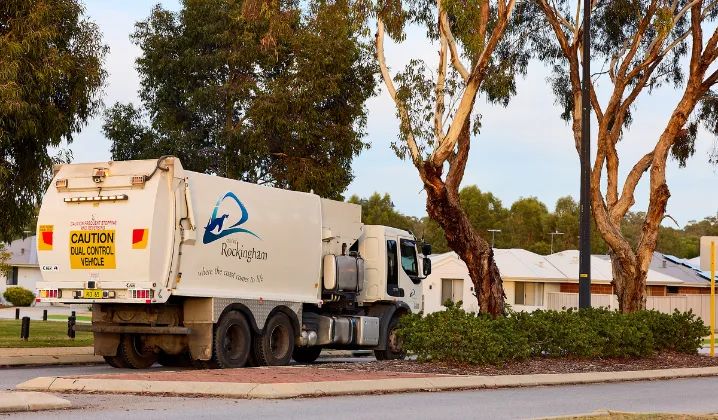 a garbage truck parked on the side of a road