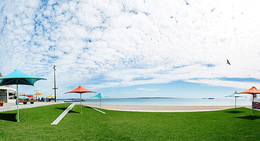 a beach with umbrellas and a body of water