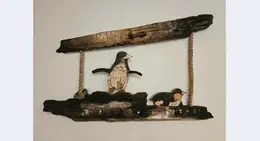 a penguin and penguin on a wooden swing