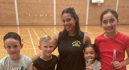a group of kids and a woman in a gym