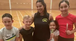 a group of kids and a woman in a gym