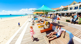 people sitting on benches at a beach