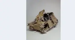 a piece of cardboard with white threads