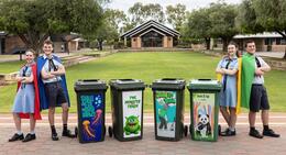 Kolbe Catholic College students stand beside colourful bin brigade bins with anti-litter messages.