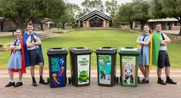 Kolbe Catholic College students stand beside colourful bin brigade bins with anti-litter messages.
