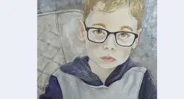 a boy wearing glasses and a vest