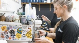 a woman making coffee at a coffee machine