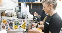a woman making coffee at a coffee machine