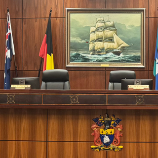 a desk with chairs and flags in front of a painting