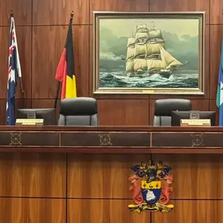 a desk with chairs and flags in front of a painting