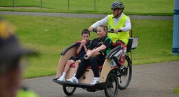 a man riding a bicycle with a woman and a boy