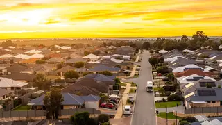 a street with cars and houses in the background