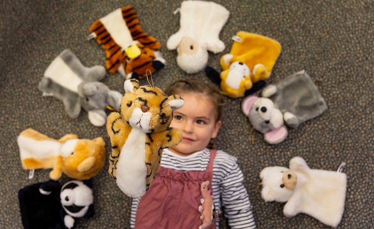 Girl playing with puppets.