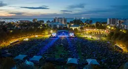 a large outdoor concert with a crowd of people in the foreground