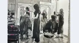 a woman curling her hair in a mirror